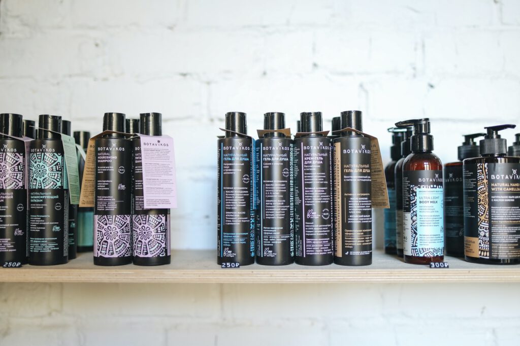 Bottles of shampoos and conditioners are standing on a wooden shelf