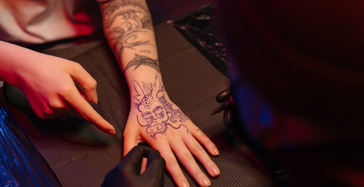 Dragon tattoo on a woman's hand tattooed by tattoo artist
